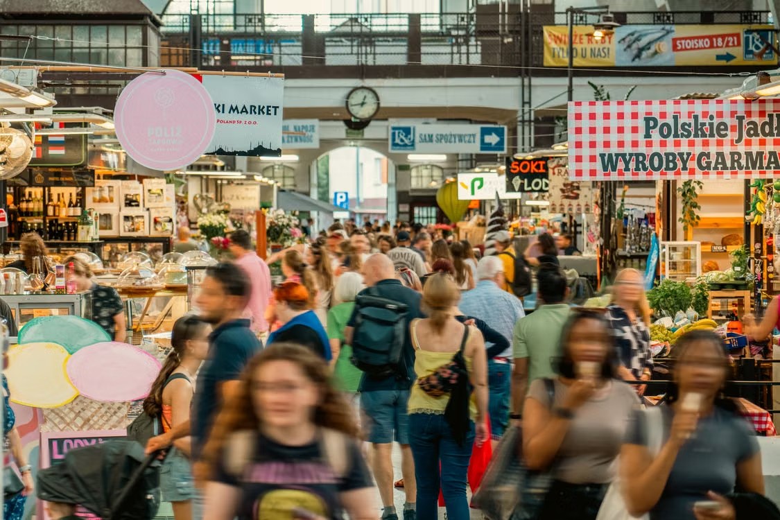 Osoby przechodzą między stoiskami w Hali Targowej we Wrocławiu